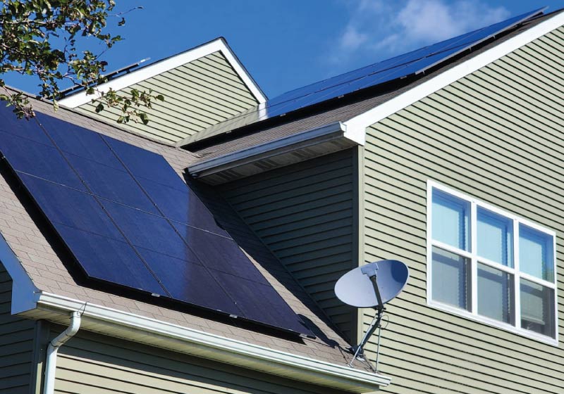 Modern residential solar panel system seamlessly integrated onto a peaked roof, providing homeowners with significant energy savings and 30 years of protected workmanship.