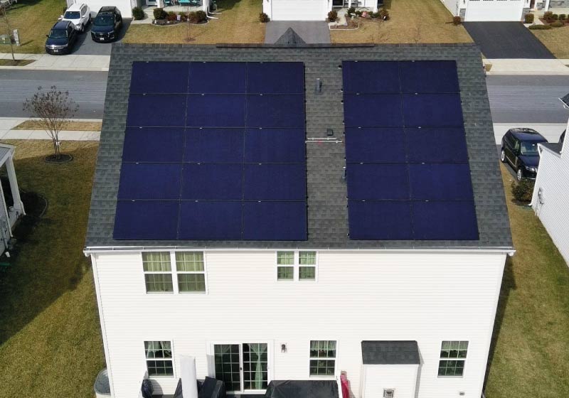 Symmetrical overhead view of a massive solar array on a suburban white home, illustrating Cosmo Solaris’s ability to scale energy solutions for high-usage households.