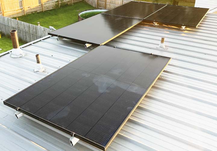 Close-up of solar panels expertly mounted on a light-colored metal roof, demonstrating Cosmo Solaris’s commitment to quality equipment and long-term reliability.