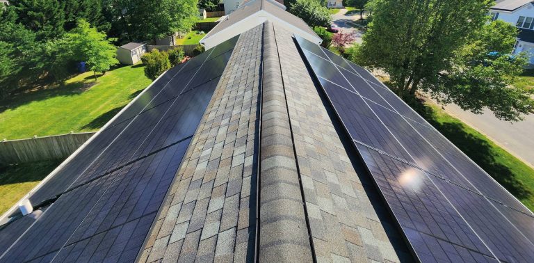 High-angle perspective of a symmetrical solar panel installation by Cosmo Solaris on a peaked asphalt shingle roof, demonstrating precision engineering and maximum sun exposure for homeowners.
